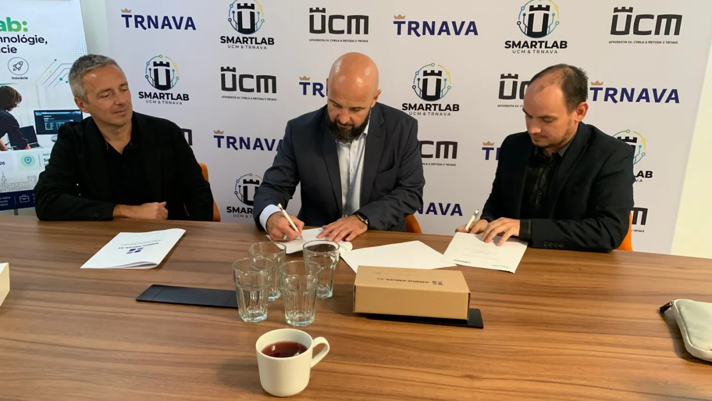 Podpis memoranda o spolupráci za stolom, v pozadí logá UCM, SMARTLAB a Trnava